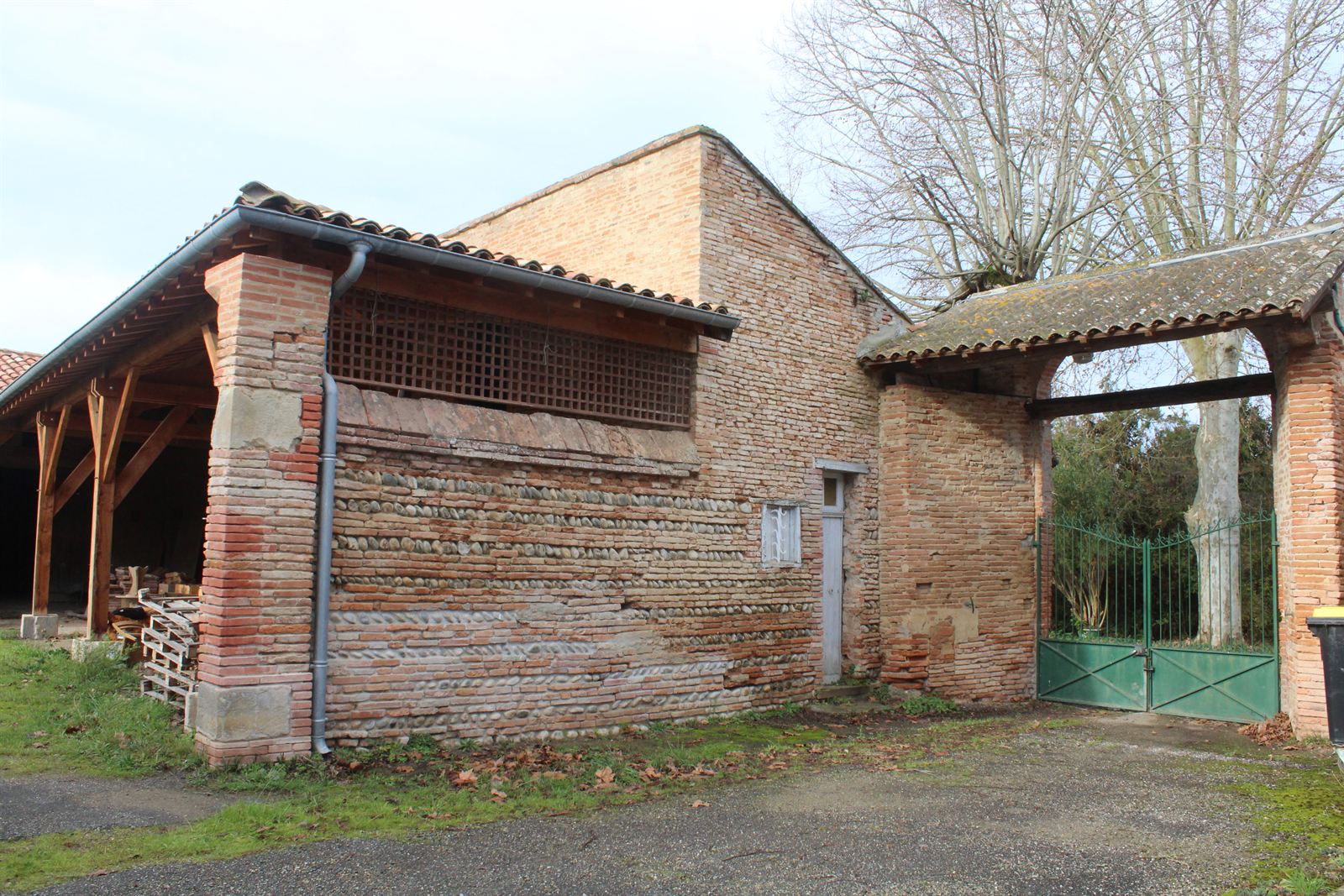 A brick agricultural building inside the monastic enclosure, with a wide doorway.