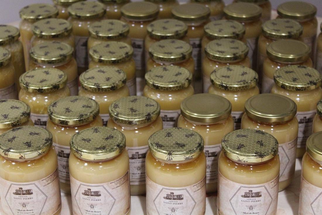 Preserving jars filled with fruit and vegetables, ranked on a shelf.