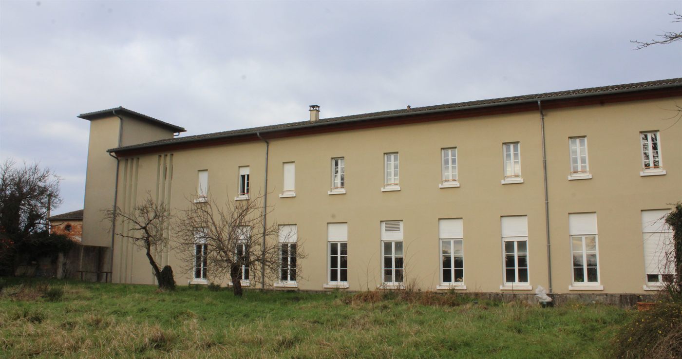 Building C seen from the garden: a long two-storey range with regularly spaced windows on both floors.