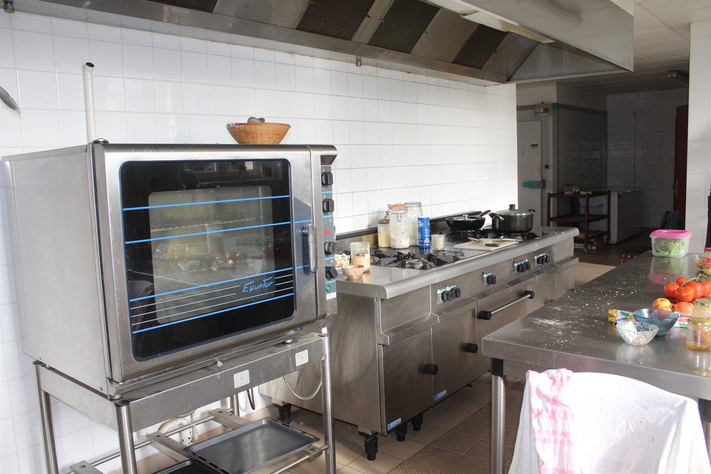 The workshop's professional kitchen: a gas range and convection oven under a stainless extraction canopy.